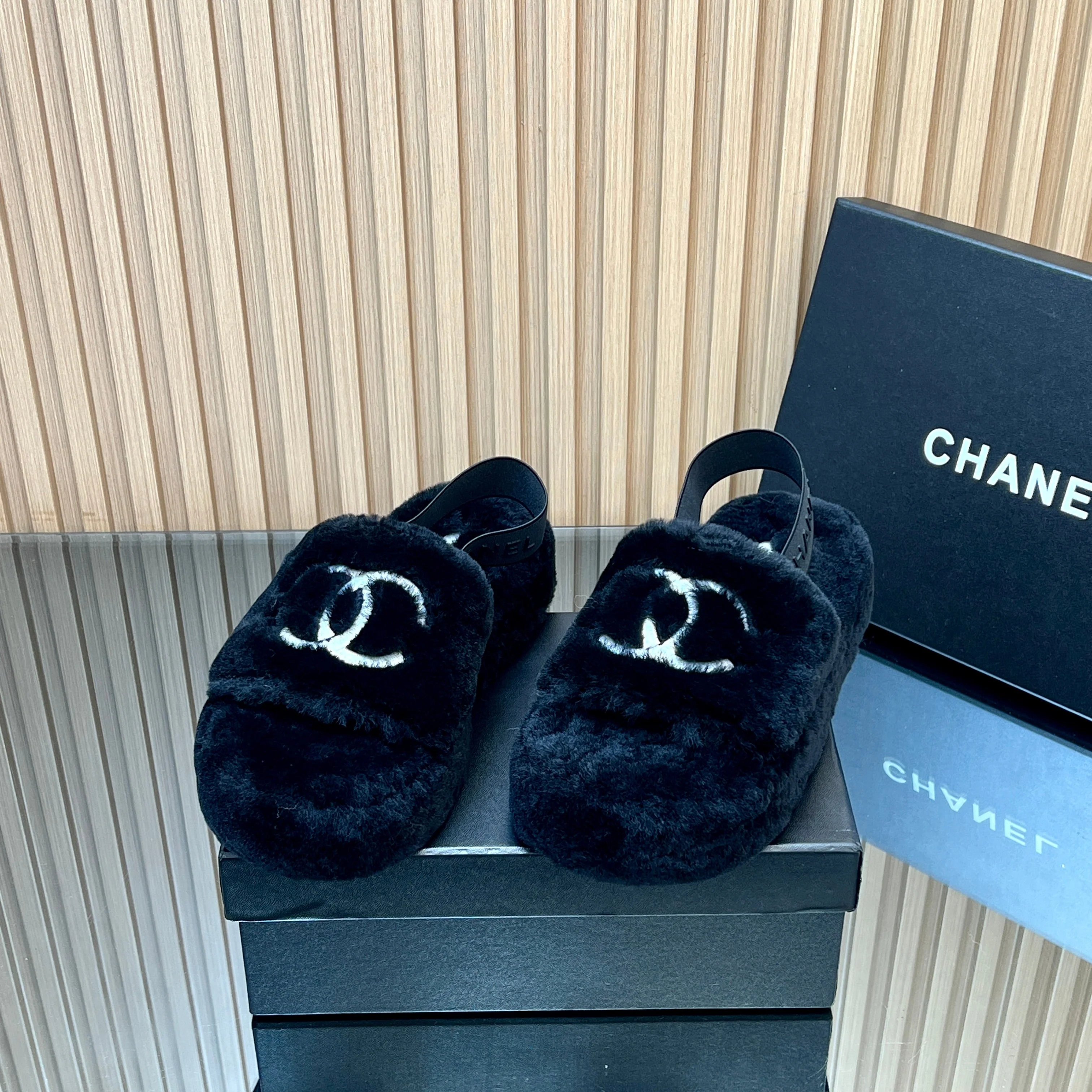 CHANEL 25S THICK-SOLED FURRY SLIPPERS WITH ELASTIC STRAPS IN BLACK FUR
