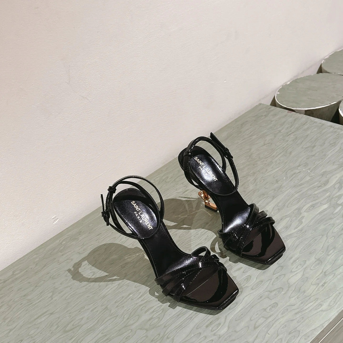 YSL 25S HIGH-HEEL SANDALS 100 MM IN BLACK GLOSSY LAMBSKIN WITH YSL LOGO HEEL DESIGN IN GOLD